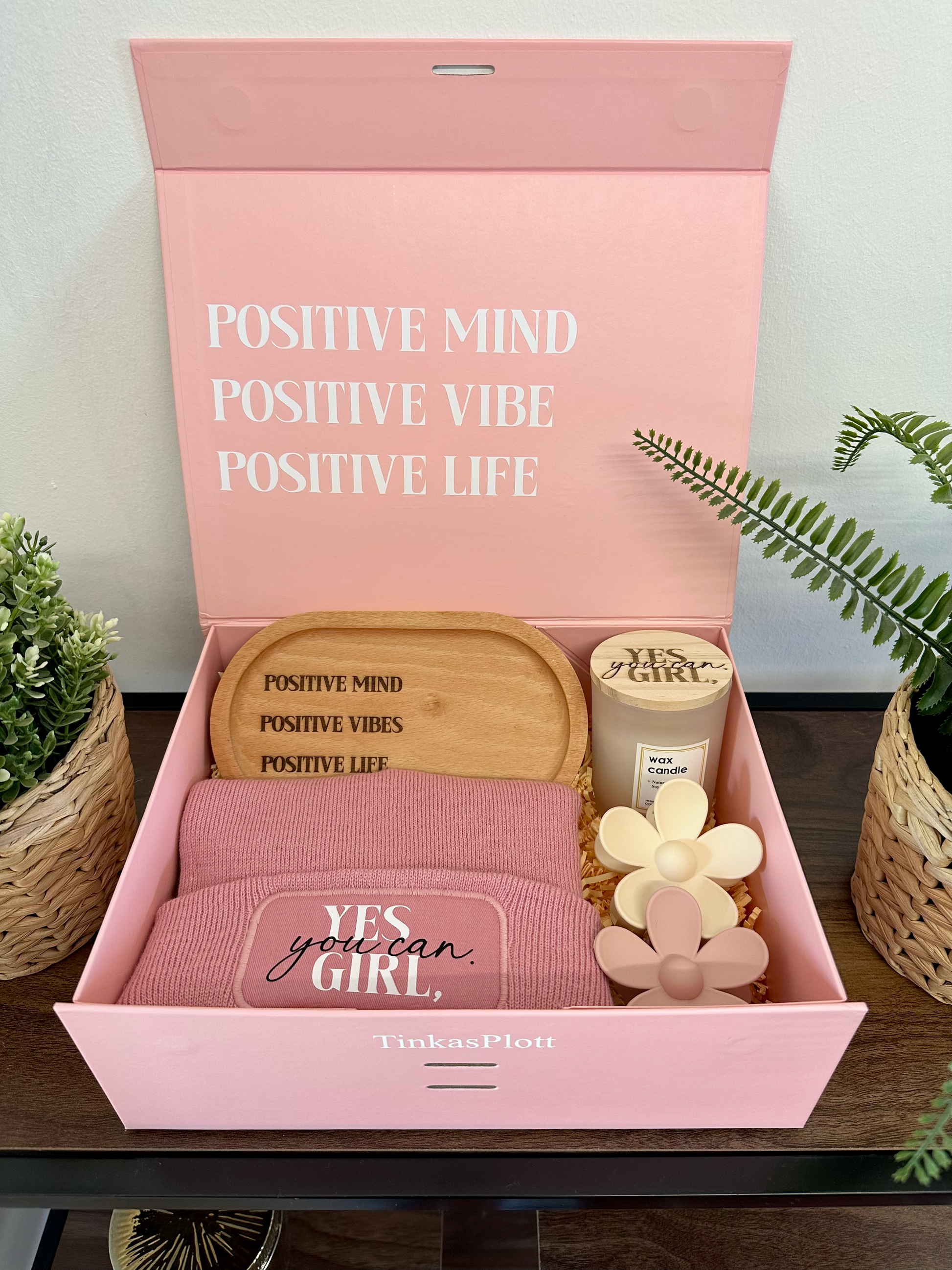 Stilvolles Geschenkset mit Beanie, Duftkerze Fresh Flower, zwei Blüten-Haarklammern und einem gravierten Tablett aus Buche. Die Box ist perfekt als Geburtstagsgeschenk oder Weihnachtsgeschenk für Frauen – alles sicher eingebettet in Papierfüllung.